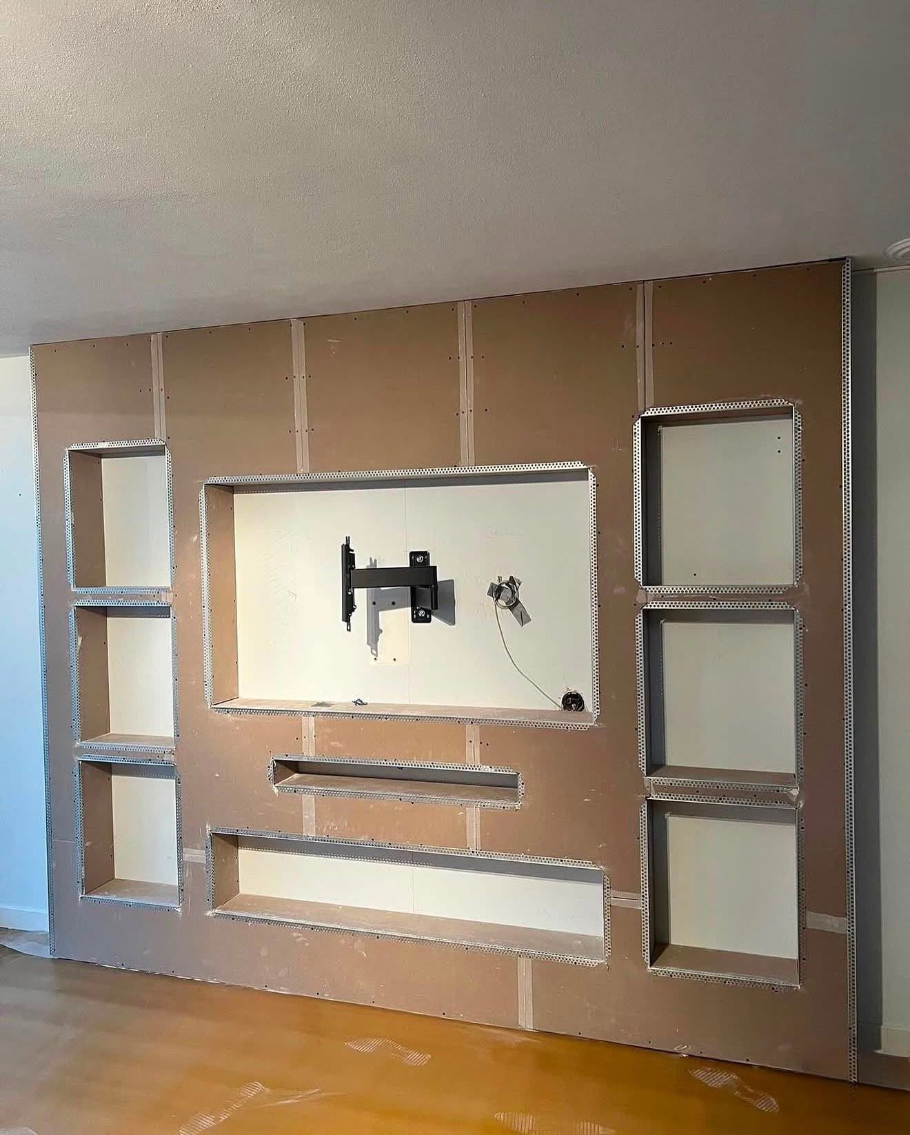 Tv-wand van gipsplaat met nissen en hoekprofielen, tijdens de bouw