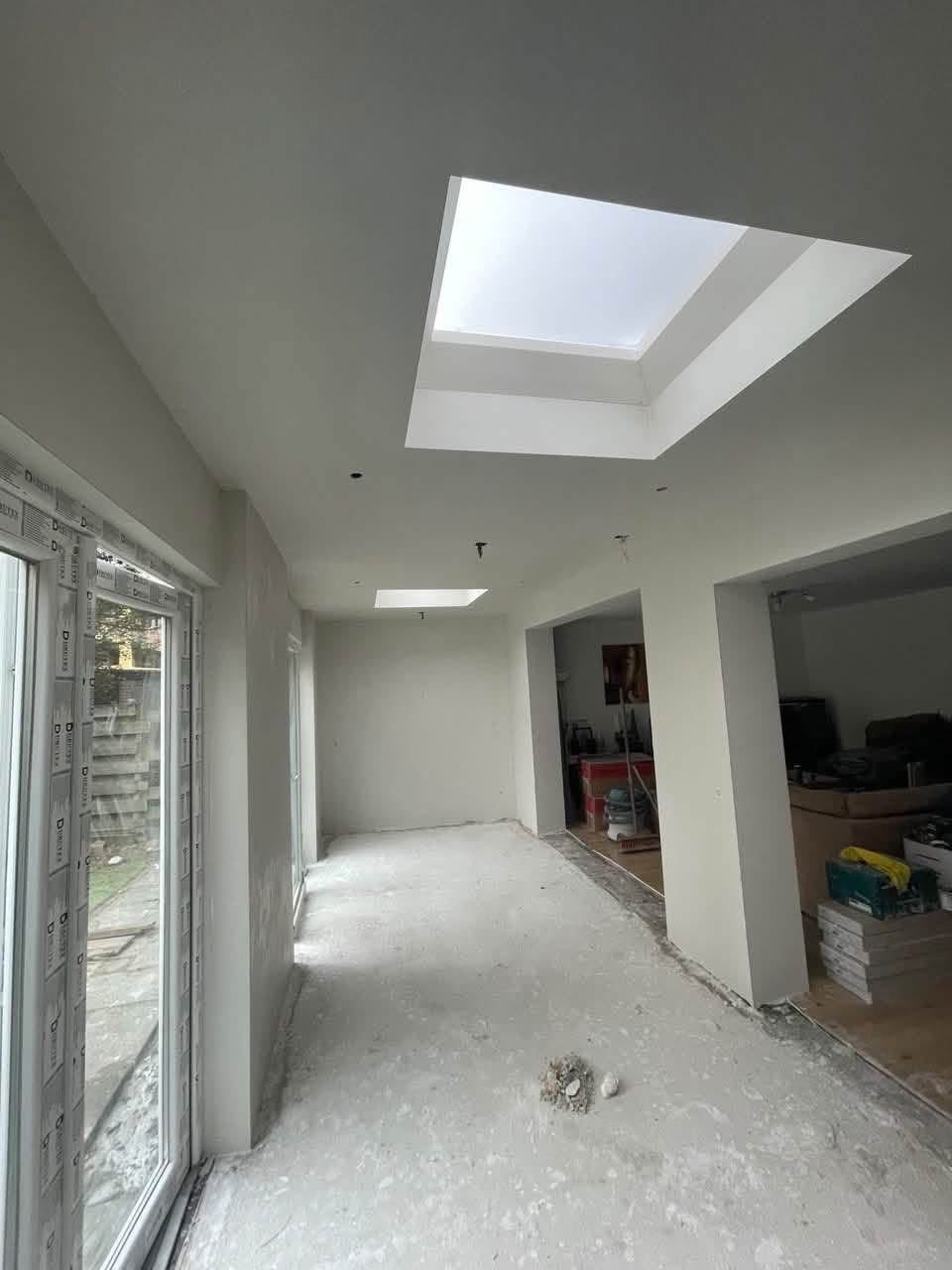 Nieuwe uitbouw met twee lichtstraten in het plafond en strak gestucte wanden