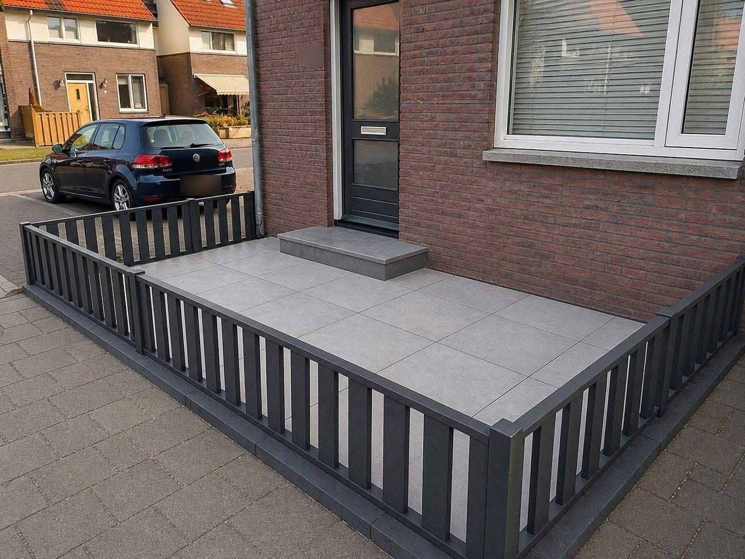 Voortuin met grote grijze keramische tegels, nieuwe stoep en antraciet hekwerk